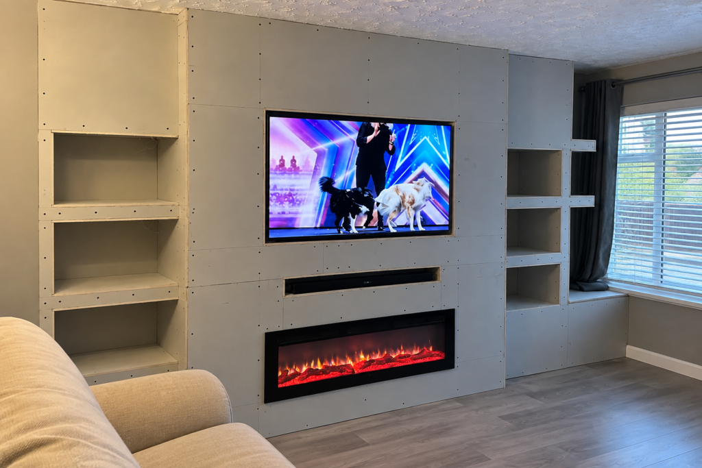 Media wall under construction with recessed TV, electric fireplace and shelving, built by Top Grain Carpentry in Stourport-on-Severn.